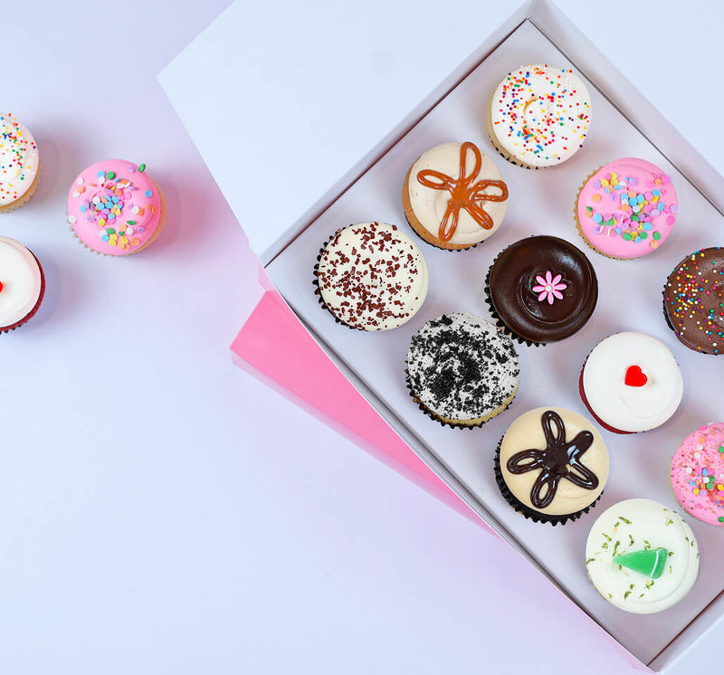 Assorted cupcakes arranged inside an open gift box