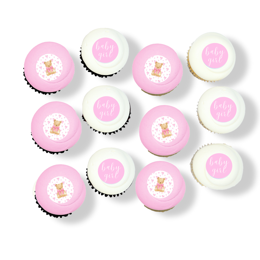 Pink and white cupcakes with baby girl-themed toppers