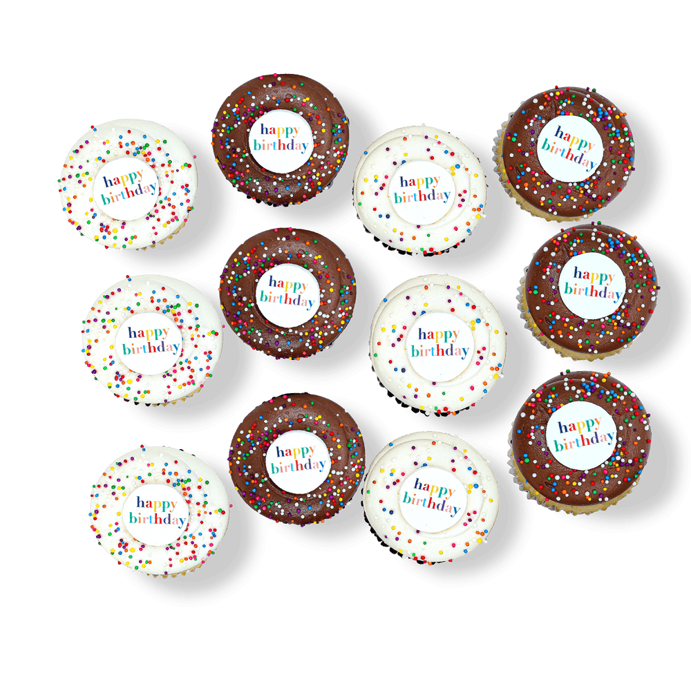 Birthday cupcakes with white and chocolate frosting, sprinkles, and “Happy Birthday” toppers