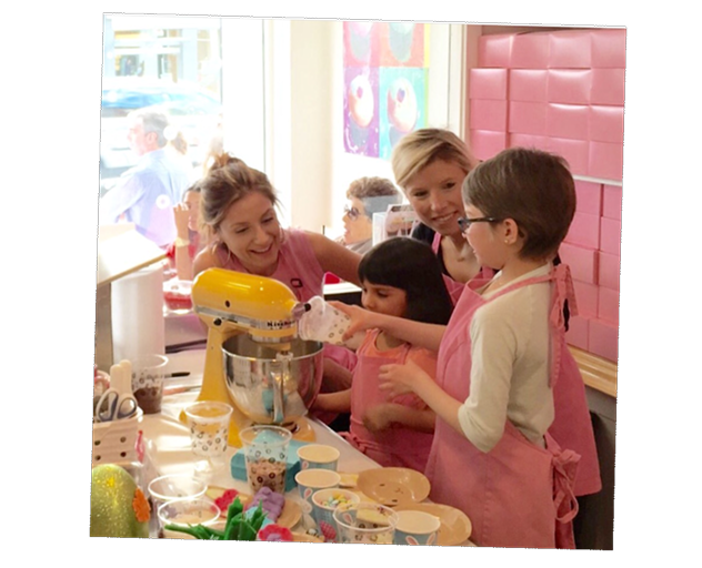 Adults and children baking cupcakes together during a hands-on baking class