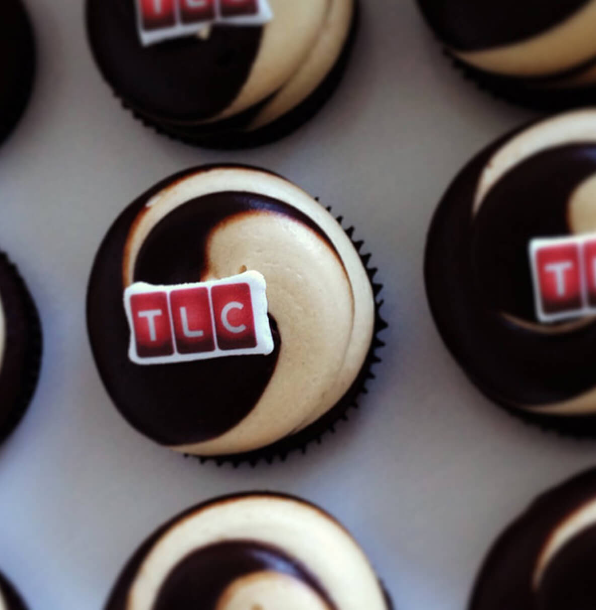 Cupcakes decorated with company logo toppers