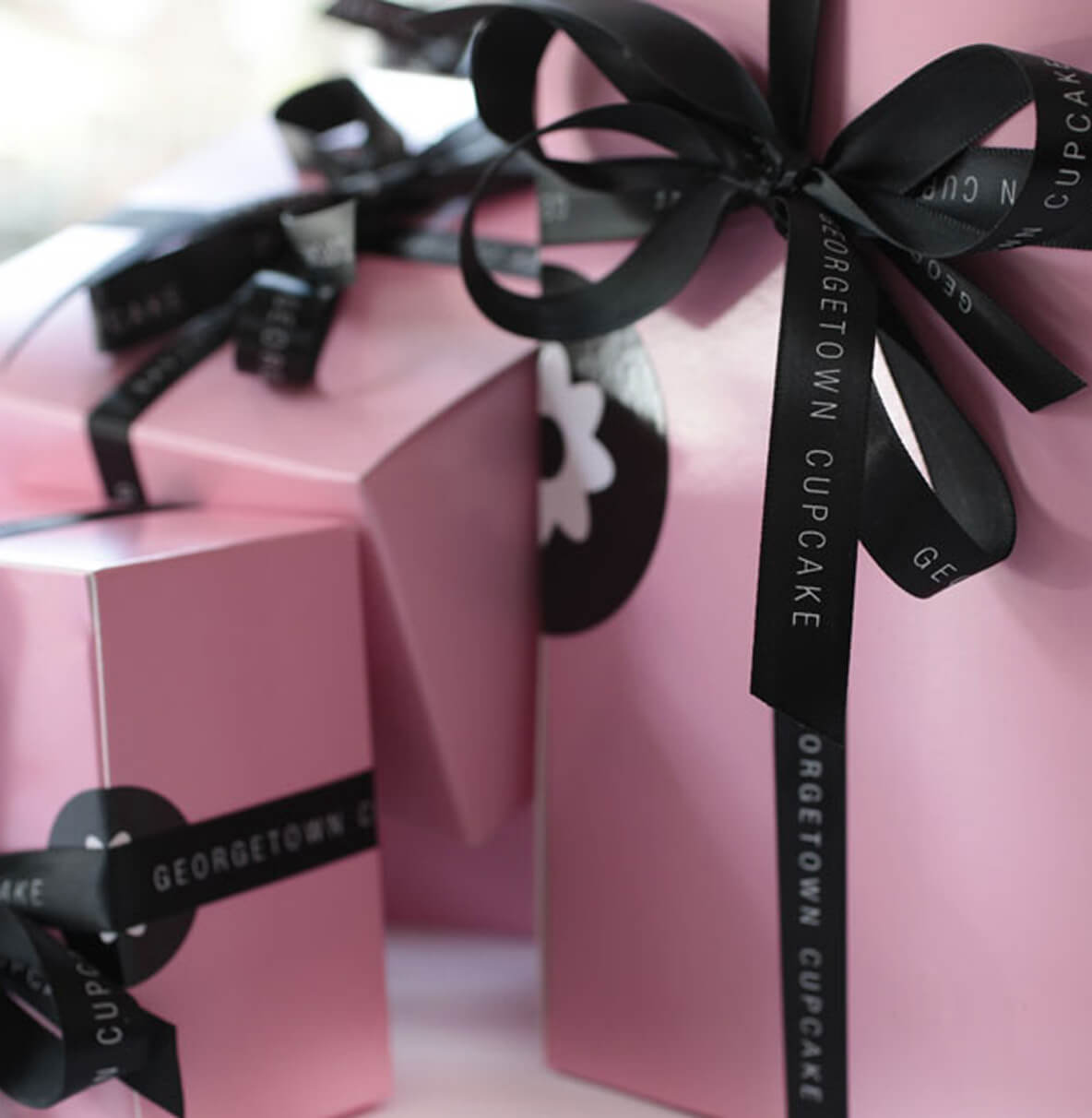 Pink gift boxes tied with black Georgetown Cupcake branded ribbon